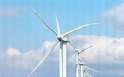 Wind turbines against a cloudy sky.